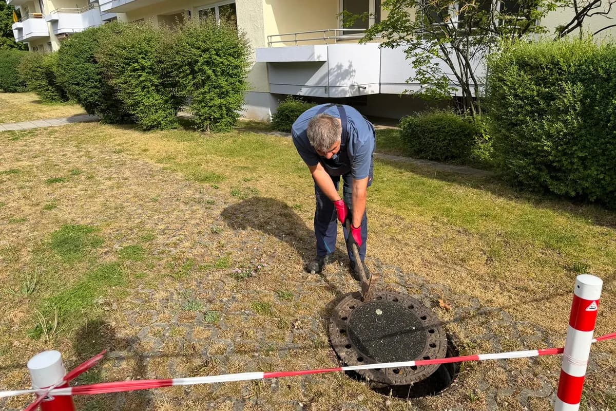 Geöffneter Hausanschlussschacht im Garten — Einsatz der ABH Rohrreinigung mit Absperrband zur Arbeitssicherheit