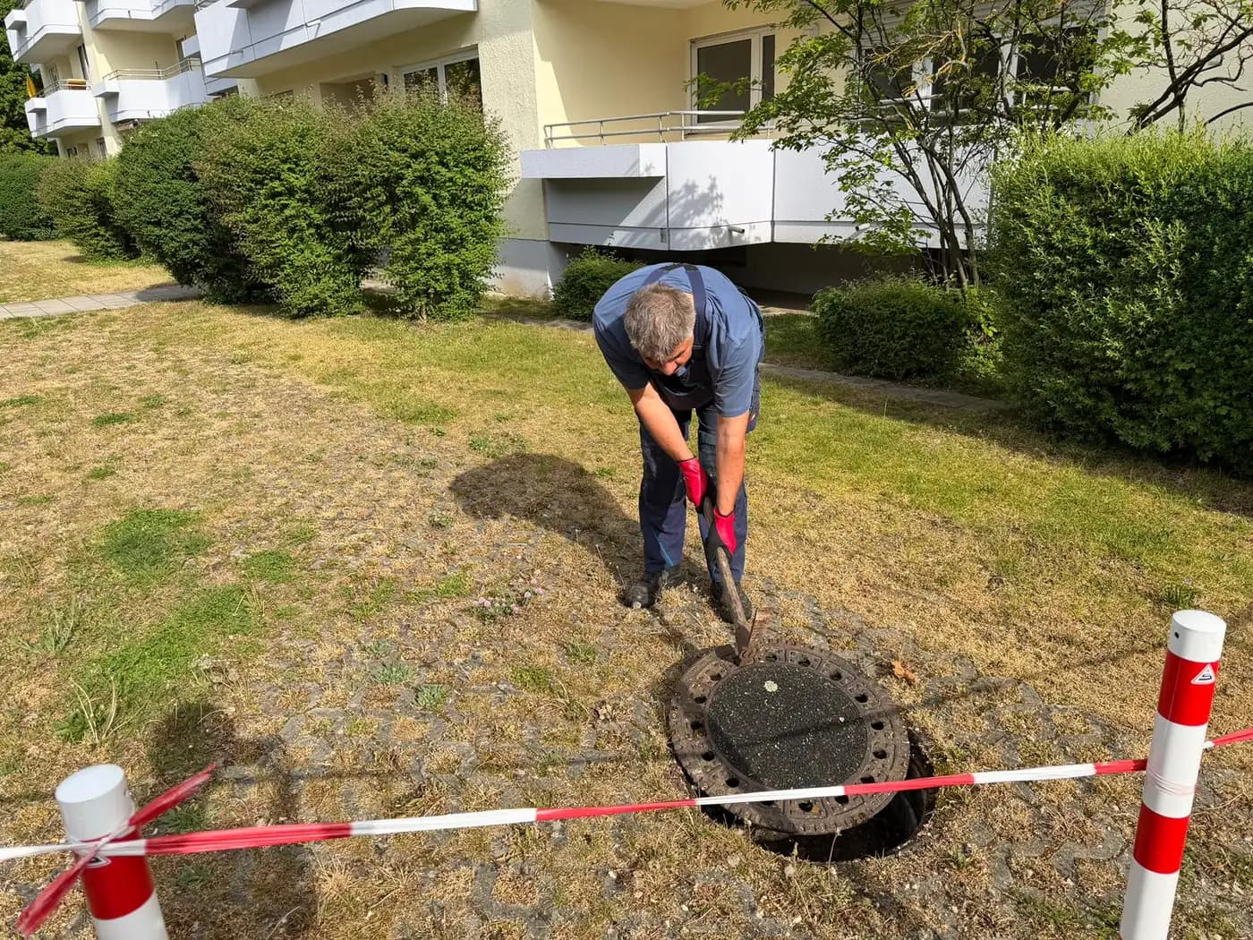 Roland Appel von ABH Rohrreinigung bei einer Kanalreinigung am offenen Hausanschlussschacht im Garten